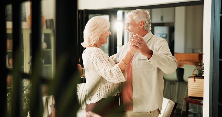 Couple laughing and dancing together at home