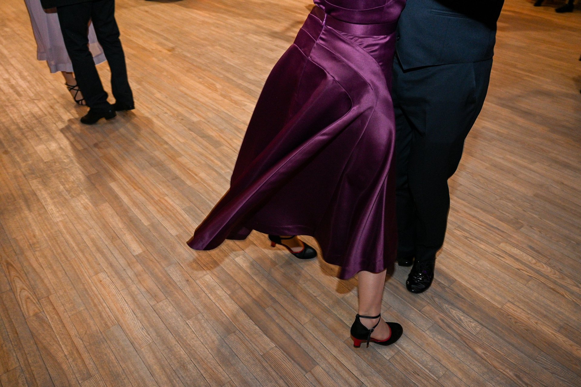 Couple dancing ballroom together in an elegant studio with warm lighting
