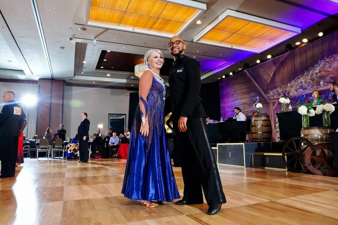 Couple dancing in formal attire at an upscale event venue with modern lighting and decorated ballroom